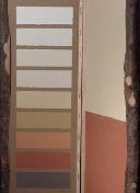 Lehmfarbmuster in Beige-, Orange- und Rottönen neben Rotbraun gestrichener Wand