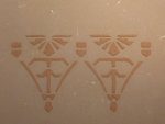Zwei symmetrische Ornamente in Schablonentechnik auf Lehmputz