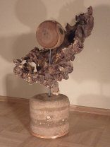Löchriges Wurzelholz mit Holzscheibe auf Sockel